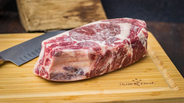 Fleisch und Messer auf einem Bambus-Schneidebrett mit umlaufender Saftrinne