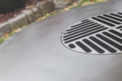 Detail einer Remundi Feuerplatte mit eingesetztem Grillrost in der Mitte